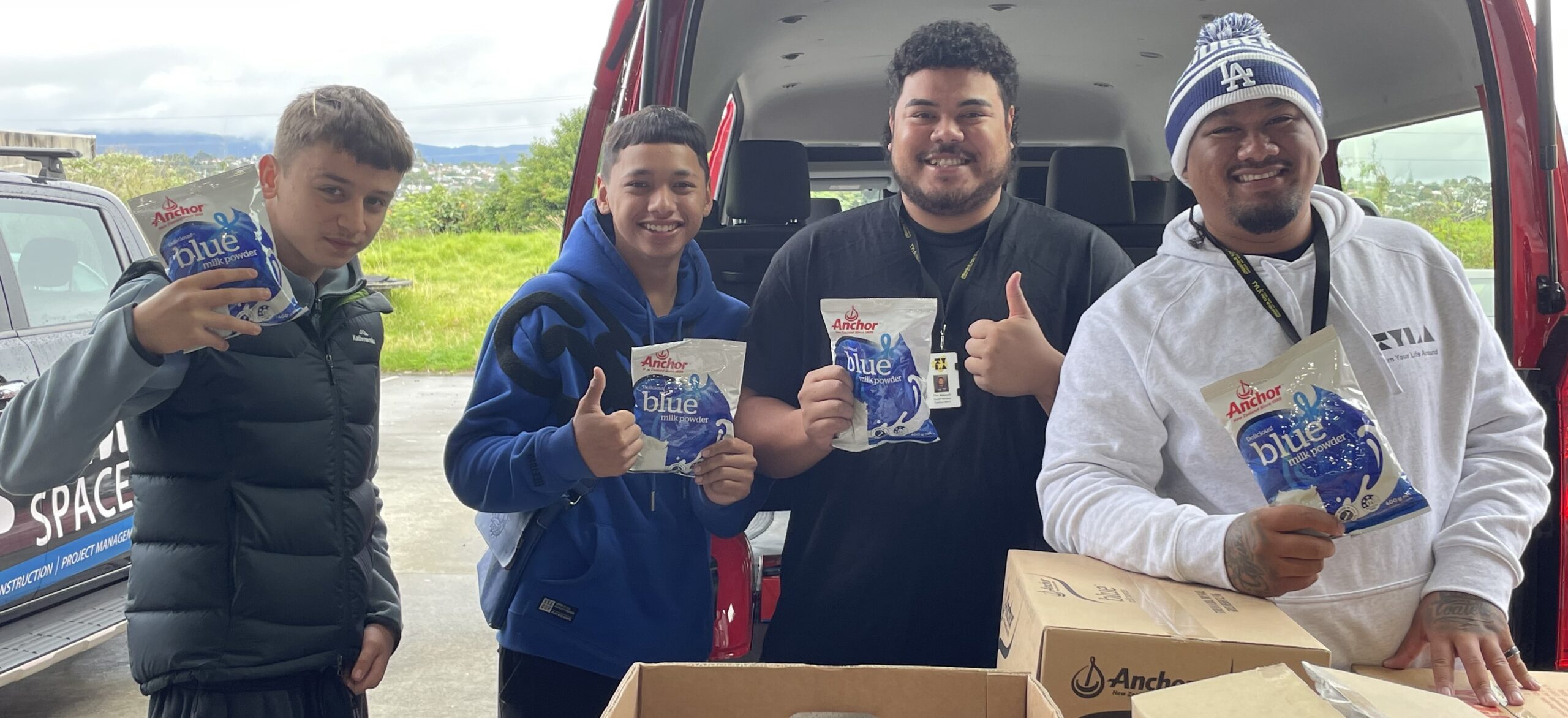 Fair Food donation recipients holding donated milk powder