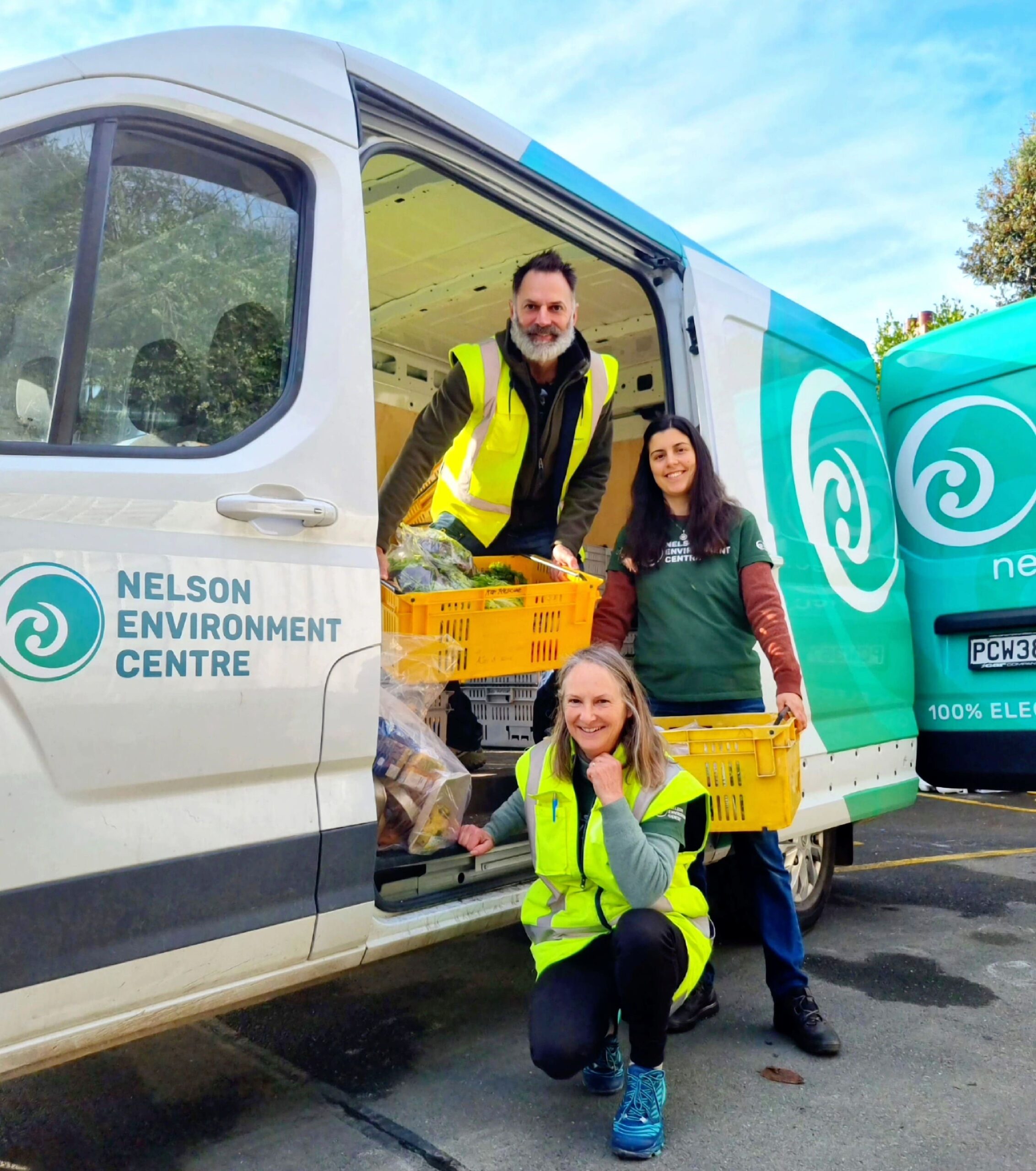 NEC staff outside their delivery van holding food baskets