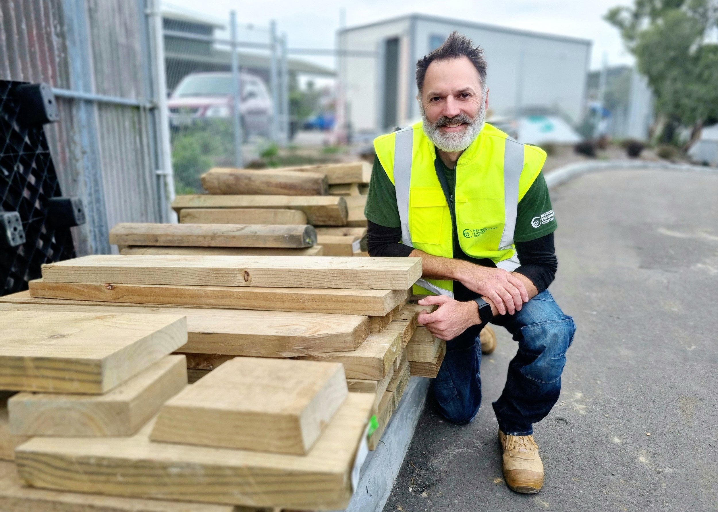 NEC staff next to some recycled construction materials.